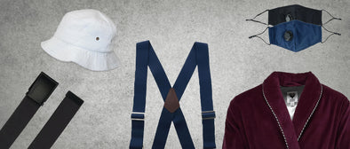 A display featuring black socks, a white hat above it, suspenders in the middle of the page, and a suit jacket and face mask to the right
