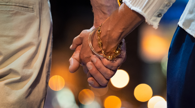 A closeup image of a couple holding hands.