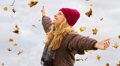 Woman throwing fall leaves