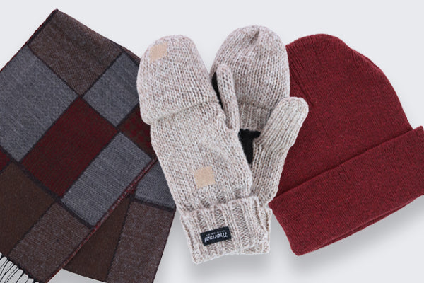 A burgundy and gray plaid scarf, a tan pair of winter mittens, and a burgundy winter hat